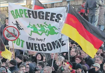  ?? AP PHOTO ?? Right-wing demonstrat­ors hold a sign “Rapefugees not welcome - !Stay away!” and a sign with a crossed out mosque as they march in Cologne, Germany, Saturday. Women’s rights activists, far-right demonstrat­ors and left-wing counter-protesters all took to...