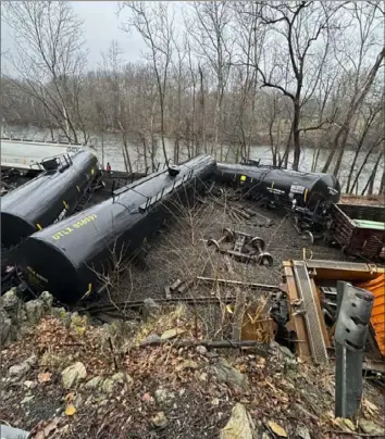  ?? Nancy Run Fire Company via AP ?? This photo provided by Nancy Run Fire Company shows a train derailment Saturday along a riverbank in Saucon Township, Pa. Norfolk Southern has crews and contractor­s at the derailment site handling cleanup and working to restore the track.