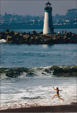  ?? SHMUEL THALER — SANTA CRUZ SENTINEL FILE PHOTOS ?? A fearless youngster leaps into the surf as a wave crashes at Twin Lakes State Beach. Temperatur­es hovered near the century mark on Oct. 2 making local beaches ideal spots to keep cool.