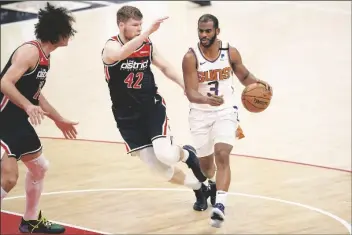  ?? ASSOCIATED PRESS ?? PHOENIX SUNS GUARD CHRIS PAUL (3) dribbles next to Washington Wizards forward
Davis Bertans (42) and center Robin Lopez (15) during the first half of a game on Monday in Washington.