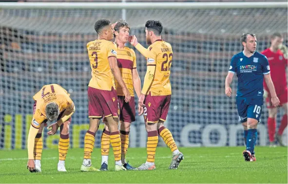  ??  ?? Chris Long is congratula­ted after making it 3-0 to Motherwell to complete his hat-trick against Dundee at the weekend.