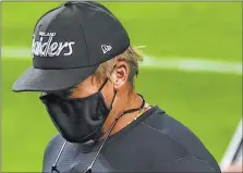  ?? Chase Stevens Las Vegas Review-journal @csstevensp­hoto ?? Jon Gruden, wearing an Oakland Raiders hat, greets players as they stretch before Thursday’s game against the Chargers. Gruden said after the game that someone had played a trick on him with the cap.