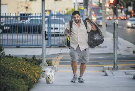  ?? Photograph­s by Francine Orr Los Angeles Times ?? MARIO BLANCO, with Leo, believes his hoarding disorder may have developed when he was a child and worsened with each hardship he faced. The former Long Beach school district security guard said he has a difficult time processing the loss of anything.