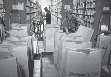  ?? BEBETO MATTHEWS/ASSOCIATED PRESS ?? Amazon.com last week touted plans to add 100,000 workers in the next 18 months, one of a number of companies making similar announceme­nts recently about plans for large-scale hiring and investing.