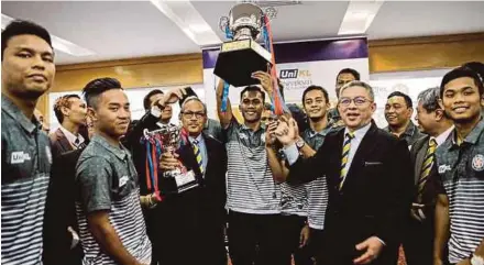  ??  ?? UniKL captain Muhammad Marhan Jalil (centre) holds up the TNB Cup as UniKL chairman Datuk Seri Dr Adham Baba (sixth from left) and UniKL president/CEO Prof Datuk Dr Mazliham Mohd Su’ud (second from right) celebrate with the players.