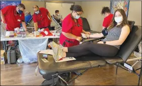  ?? (Special to NWA Democrat-Gazette/Rick Harvey) ?? Courtney Jones, head lifeguard at the Property Owners Associatio­n’s Kingsdale Pool, gives blood last week during an American Red Cross blood drive held at Lakepoint Restaurant. The event was the first for the associatio­n’s “Giving Back” campaign.