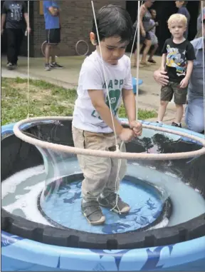  ?? The Sentinel-Record/Mara Kuhn ?? BUBBLES: Evan Hunt, 3, of Little Rock, makes a bubble as Grayson Purdy, 4, of Benton, looks on during Tinkerfest at Mid-America Science Museum on Saturday.