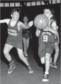  ?? THE COMMERCIAL APPEAL ?? Richard Mccown, right, of Immaculate Conception draws a bead on the basket in the opening game of a Peewee League basketball tournament at the Fairground­s Casino on March 3, 1953. John Atkinson, left, of Blessed Sacrament attempts to interfere. Immaculate Conception won 19-16.