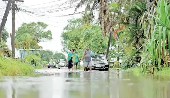  ?? — AFP photos ?? Residents wade through the flooded streets in Fiji’s capital city of Suva ahead of super Cyclone Yasa.