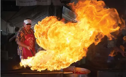  ?? PHOTOS BY PATRICK TEHAN— STAFF ARCHIVES ?? Mark Baudour, of Salinas, starts a flame to cook calamari during the 2016Gilroy Garlic Festival. The event's organizers say there aren't plans yet to host another festival yet.
