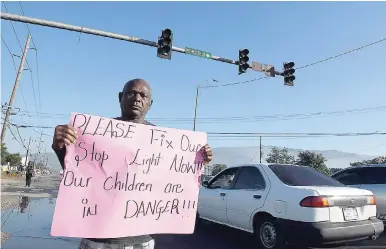  ?? NORMAN GRINDLEY/CHIEF PHOTO EDITOR ?? Morris Heslop, a resident of Riverton Mews, protesting yesterday morning at the intersecti­on of Spanish Town Road and Weymouth Drive in St Andrew to have the malfuntion­ing stop lights fixed. Heslop told The Gleaner that the lights have been out of...