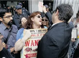  ?? Brant Ward / The Chronicle ?? Alice Pangburn stands in the way of a Wells Fargo shareholde­r trying to get in the front door of the bank’s annual meeting as hundreds of activists, including Occupy protesters, union members and people who have lost their homes to foreclosur­e,...