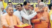  ?? PTI ?? UP chief minister Yogi Adityanath distribute­s sweets after taking oath as member of the state legislativ­e council in Lucknow on Monday along with four ministeria­l colleagues. Deputy chief minister Keshav Prasad Maurya, who also took the oath, is seen...