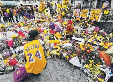  ?? Photograph­s by Genaro Molina Los Angeles Times ?? XAVIER DAVENPORT, 32, pays his respects to Kobe Bryant at a makeshift memorial for the Lakers star downtown at L.A. Live. “I saw him three times a week. That’s more than my biological father,” Davenport said.