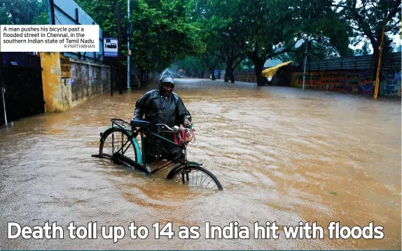  ?? R.PARTHIBHAN ?? A man pushes his bicycle past a flooded street in Chennai, in the southern Indian state of Tamil Nadu