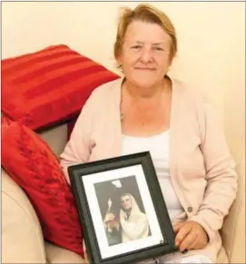  ??  ?? Noreen McAuliffe, the only survivor of a house fire in Macroom, holding a picture of her son, Kenneth Relihan who perished in the fire along with a family friend, Noel O’Mahony.