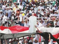  ?? Reuters ?? Faithful hold a cardboard depicting Pope Francis as he arrives to lead a mass in Cairo yesterday.