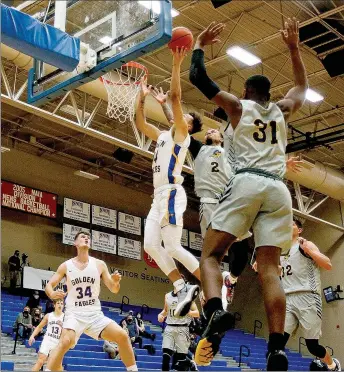  ?? Photo courtesy of JBU Sports Informatio­n ?? John Brown sophomore James Beckom drives to the basket through Texas Wesleyan defenders during Thursday’s game.