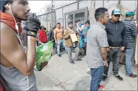  ?? Gary Coronado Los Angeles Times ?? MIGRANTS wait to register for work permits in Tijuana. Mexico’s top immigratio­n official says it can’t handle fresh waves of people awaiting U.S. asylum cases.