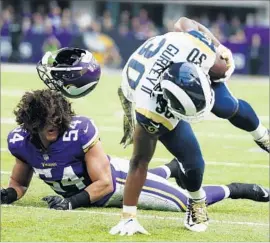  ?? Bruce Kluckhohn Associated Press ?? RAMS RUNNING BACK Todd Gurley does a balancing act while getting away from Minnesota Vikings linebacker Eric Kendricks in the first half.