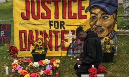  ?? Photograph: Stephen Maturen/Getty Images ?? Antwon Davis lights candles at a memorial for Daunte Wright on 2 May 2021 in Brooklyn Center, Minnesota.