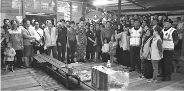  ??  ?? Madiyem (eight right) and the District Natural Disaster Committee members visiting the flood victims evacuated to Kampung Ponontomon cultural house.