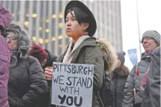 ??  ?? Un joven sostiene una veladora y un cartel en el que se lee “Pittsburgh, estamos contigo”, durante una vigilia contra el antisemiti­smo, ayer en Ontario, Canadá.