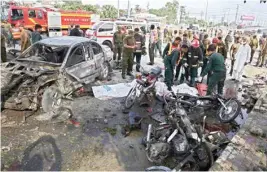  ?? AP/PTI ?? Pakistani rescue workers prepare to remove a body from the site of a deadly bombing in the eastern city of Lahore in Pakistan on Monday. Pakistani officials said that the suicide motorcycle bombing killed over 26 people and wounded more than 50 others...
