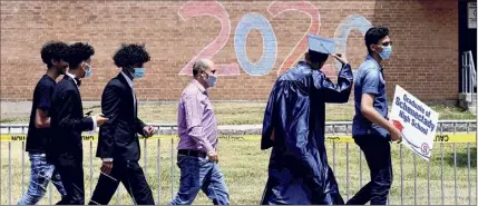  ?? Will Waldron / Times Union ?? Schenectad­y High School held its commenceme­nt on June 26. Keeping with coronaviru­s safety measures, students and family entered the school auditorium in small groups to receive diplomas.