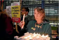  ?? AP ?? Demonstrat­ors hold banners and candles during a vigil for the 39 lorry victims outside the Home Office in London yesterday.