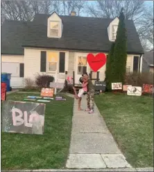  ??  ?? Neighbors of Candis Howard painted signs as a show of support after someone left razor blades with racist messages on them on the family’s front lawn.