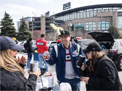  ?? ASHLEE REZIN/SUN-TIMES PHOTOS ?? Fans toast as they tailgate Thursday before the Sox home opener at Guaranteed Rate Field on the South Side.