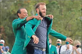  ?? AP-Charlie Riedel ?? Tiger Woods helps Masters’ champion Dustin Johnson with his green jacket after his victory at the Masters golf tournament Sunday in Augusta, Ga.