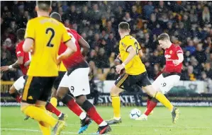  ?? — Reuters photo ?? Manchester United’s Scott McTominay (right) scores their first goal during the English Premier League match against Wolverhamp­ton Wanderers at the Molineux stadium in Wolverhamp­ton, central England.