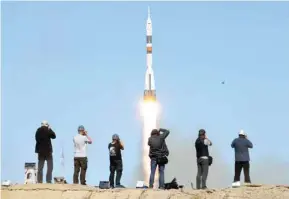  ??  ?? Photograph­ers take pictures as Russia’s Soyuz MS-10 spacecraft, carrying the members of the Internatio­nal space Station (ISS) expedition 57/58, blasts off from the launch pad at the Russian-leased Baikonur cosmodrome in Baikonur.