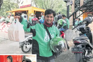  ??  ?? ABOVE
A Gojek driver prepares to deliver food in Jakarta. Drivers are now being issued large carrier bags that can hold many orders, reducing the need for individual plastic packaging.