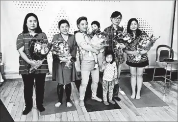  ?? STEVEN BOROWIEC/FOR TRIBUNE NEWSPAPERS ?? South Korean single moms join with their children at the end of the play. Lee Yeon-ji is second from the right, with eyeglasses. Despite the play’s serious intent about exploring the prejudices against single mothers, it also features humor.