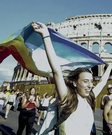  ??  ?? Colosseo Nella foto una ragazza sfila con la bandiera arcobaleno sotto all’Anfiteatro Flavio