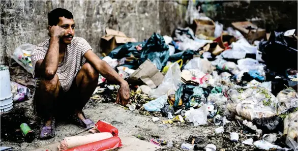  ?? (AFP) ?? DESCONSUEL­O. Un ciudadano que espera junto a un basurero que le llegue el turno para aprovision­arse de agua, es la imagen de la situación.