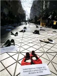  ?? — AFP file photos ?? A sign next to a pair of shoes reads ‘Isabel Martinez Holguer (67), beaten to death by her son on March 6th, 2005’ during a demonstrat­ion organised by the Chilean Network Against Domestic and Sexual Violence to mark the beginning of a campaign called ‘Male Chauvinism Kills’, to fight violence against women, at the Ahumada Walk in downtown Santiago.