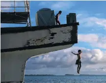  ?? PHOTO: GETTY IMAGES ?? Calm times . . . Children jump off a cyclonewre­cked ship last month into the lagoon at Funafuti, in Tuvalu.