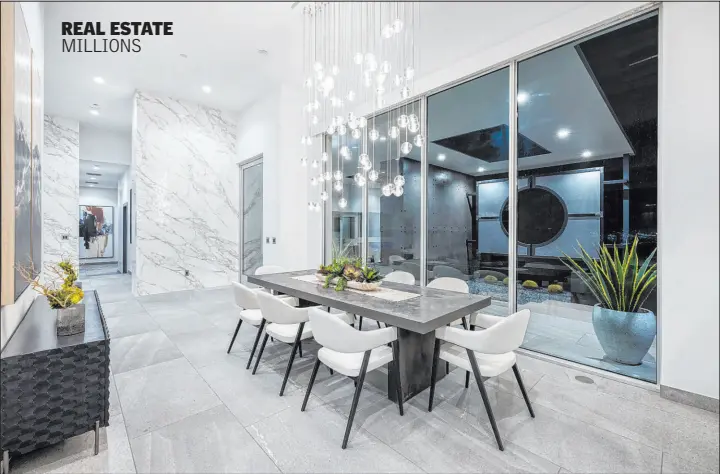  ?? Corcoran Global Living ?? This remodeled Ascaya home just sold for $5.895 million. One of the centerpiec­es of the home is the custom Bocci chandelier that hangs over the formal dining room table. The fixture, which retails for over $70,000, weighs 400 pounds.
