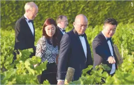  ??  ?? GUESTS WALK in the vineyards during the 65th Flower Party at Chateau Malartic-Lagraviere in Leognan, southweste­rn France, on June 21, traditiona­lly marking the end of Vinexpo, the world’s biggest wine and spirits fair.