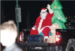 ?? NEWS PHOTO RYAN MCCRACKEN ?? Santa Claus waves to children on the street Thursday evening in Redcliff during the first night of the Santa Claus Is Coming To Town parade series, which will extend to a Saturday trip to Cottonwood and Dunmore.