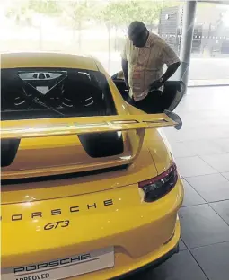  ??  ?? Billionair­e Robert Gumede and his son Matana Robert Junior Gumede and the Porsche GT3 he bought for the teenager.