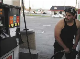  ?? PHOTO ?? Jonathen Alcadla, then 20, watches a gas pump as he fills his tank with $10 worth of gas in El Centro. IV PRESS FILE