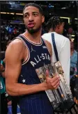  ?? (AP/Darron Cummings) ?? Indiana Pacers guard Tyrese Haliburton (0) carries the trophy Sunday after the Eastern Conference defeated the Western Conference 211-186 in the NBA All-Star game in Indianapol­is. He opened the game by making five consecutiv­e threes and finished with 32 points, 7 rebounds and 6 assists.