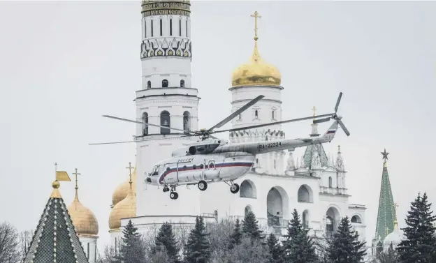  ??  ?? 0 One of Vladimir Putin’s helicopter­s flies past St Basil’s Cathedral in Moscow while preparing to land at The Kremlin yesterday