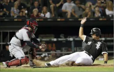  ?? CHARLES REX ARBOGAST — THE ASSOCIATED PRESS ?? The White Sox’s Jose Abreu avoids the tag of Indians catcher Roberto Perez, scoring on a single by Kevan Smith during the sixth inning.