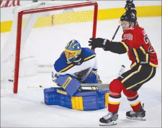  ?? The Canadian Press ?? St. Louis Blues goalie Jake Allen looks back as Calgary Flames forward Curtis Lazar, of Vernon, celebrates a third-period goal during NHL action in Calgary on Monday night. The Flames won 7-4.